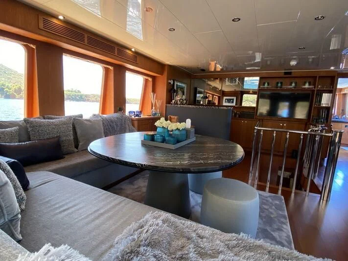 a living room with a table and couches aboard MOCEAN Yacht for Sale