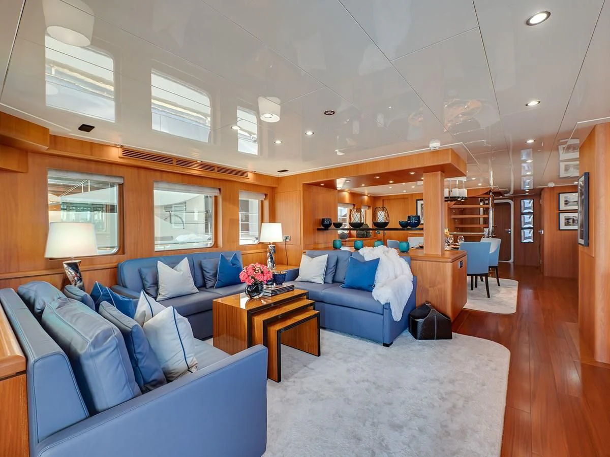 a living room with a blue couch aboard MOCEAN Yacht for Sale