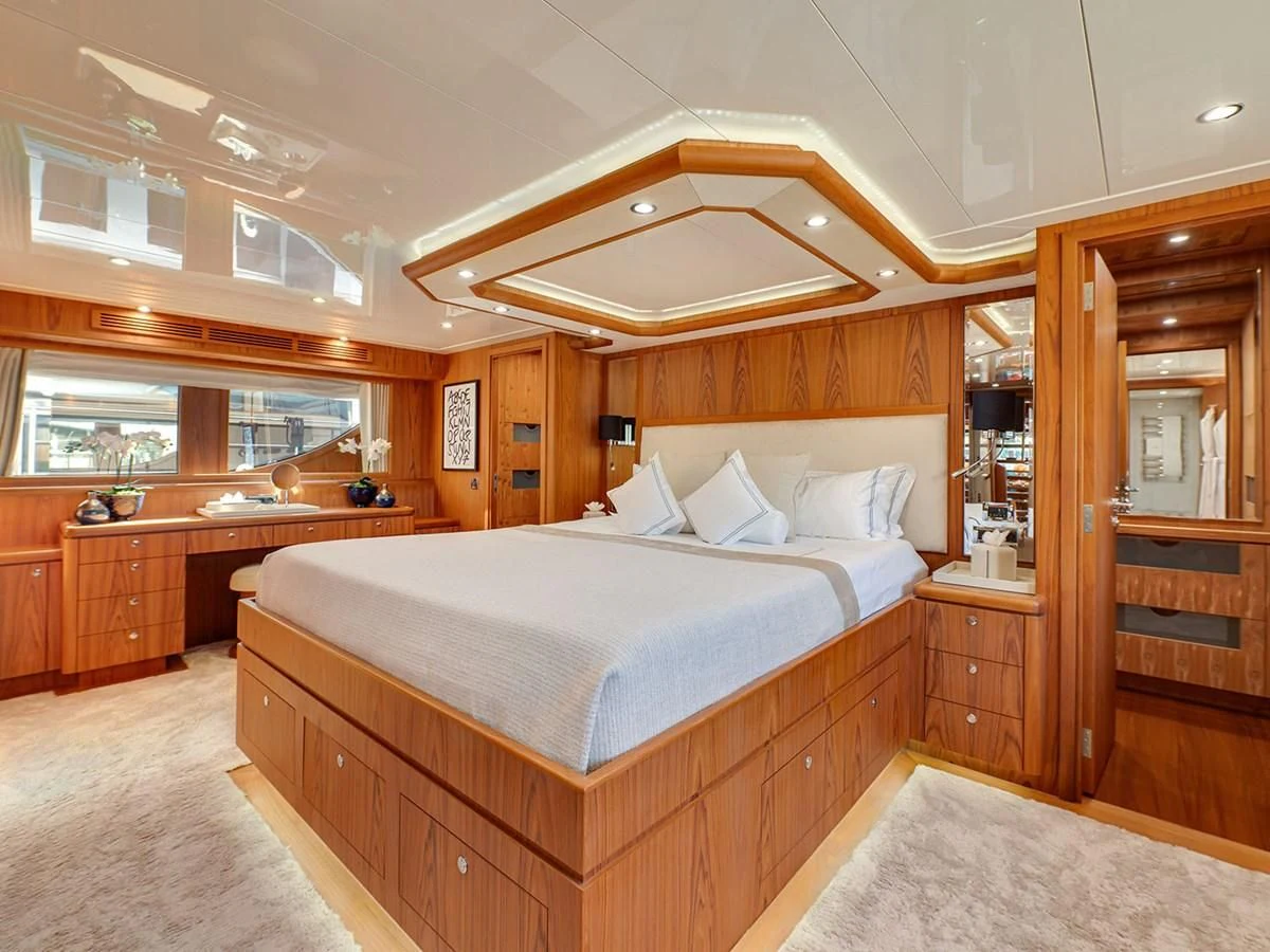 a bedroom with a bed and a wood cabinet aboard MOCEAN Yacht for Sale