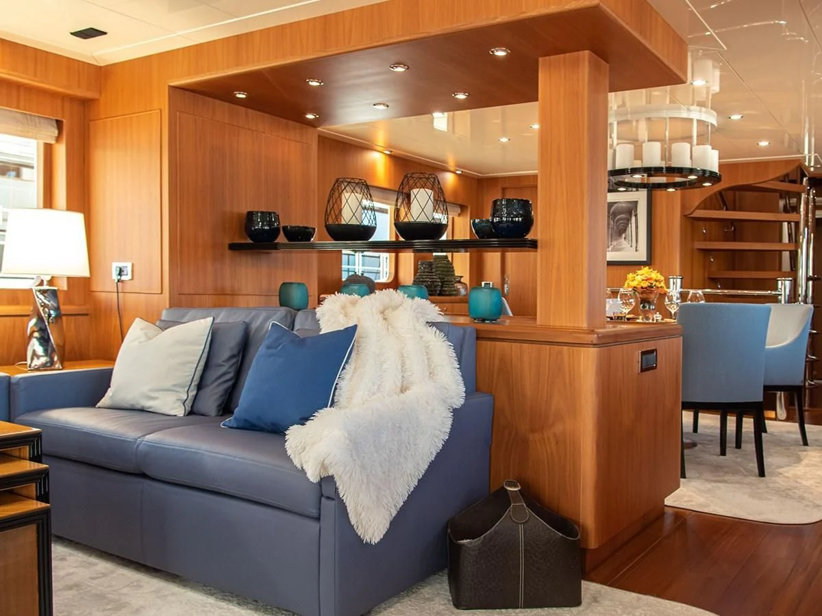 a living room with a blue couch aboard MOCEAN Yacht for Sale