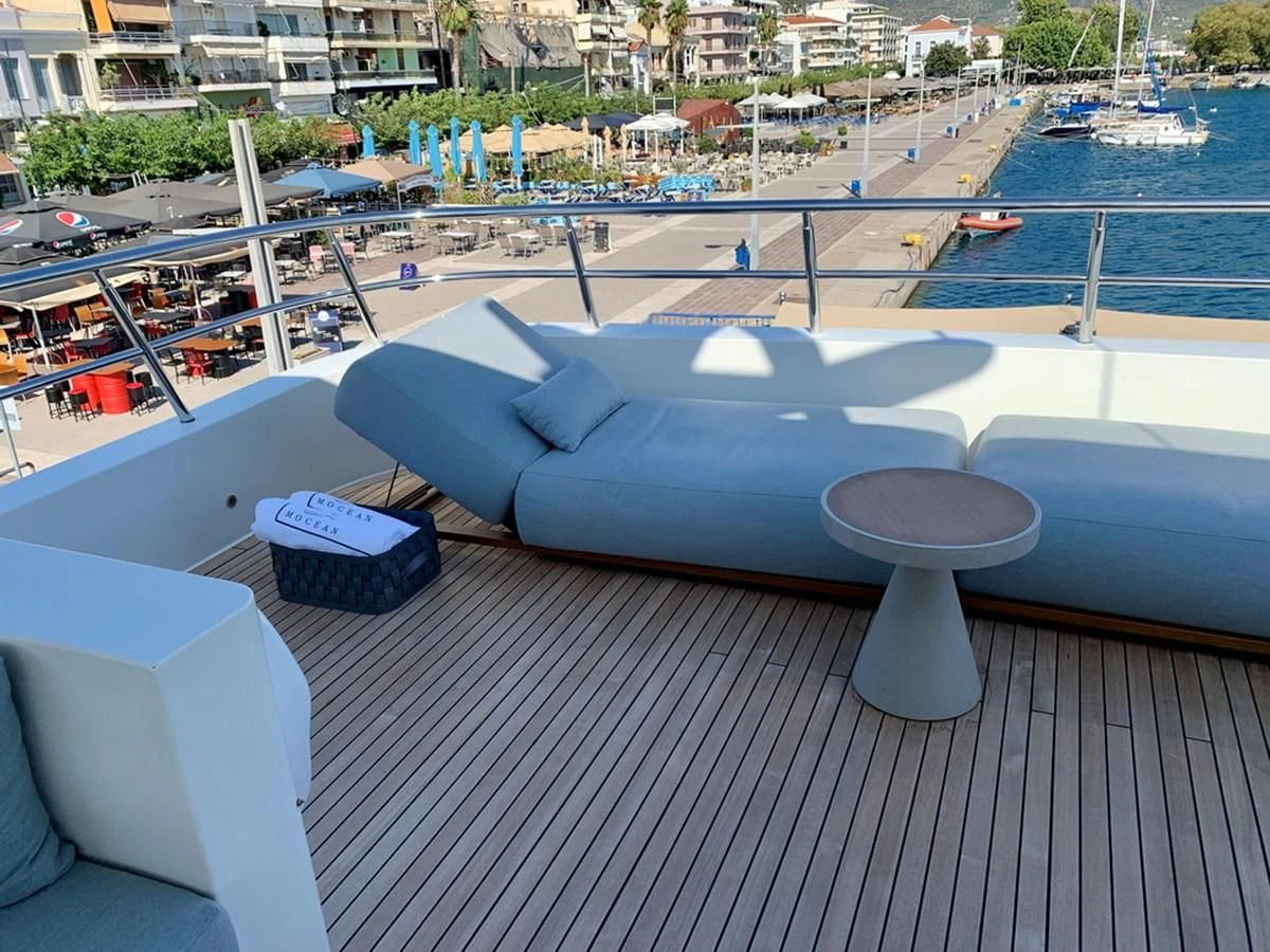 a pool with a deck and a deck with boats and a building in the background aboard MOCEAN Yacht for Sale