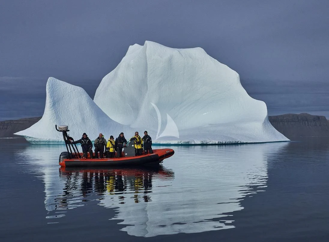a group of people on a boat in front of an iceberg aboard ROSEHEARTY Yacht for Charter