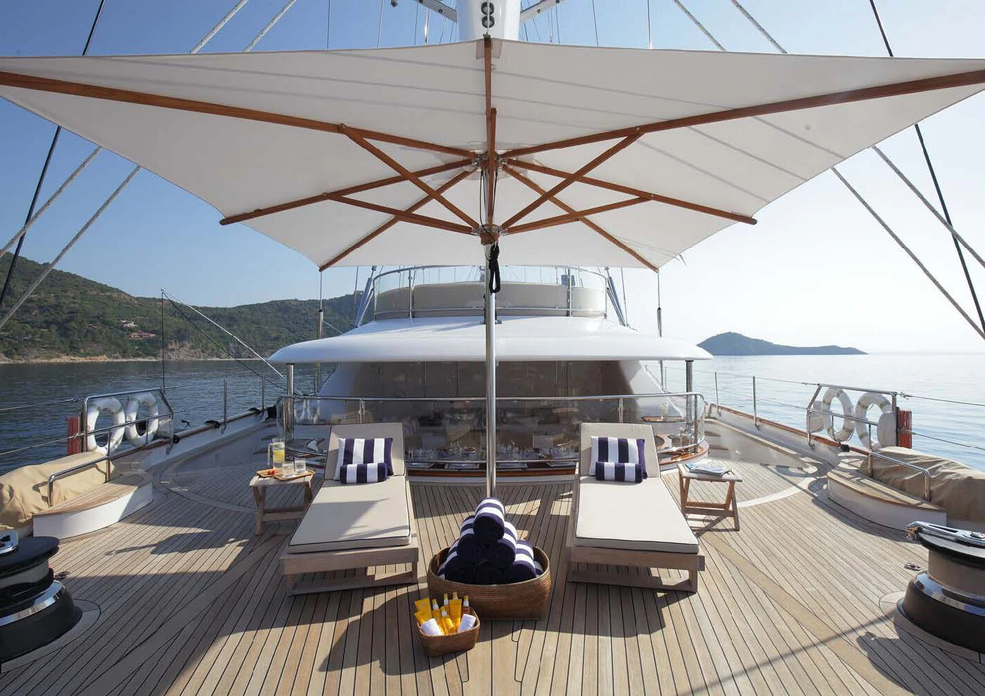 a deck with a large white boat on it and a large body of water in the background aboard ROSEHEARTY Yacht for Charter