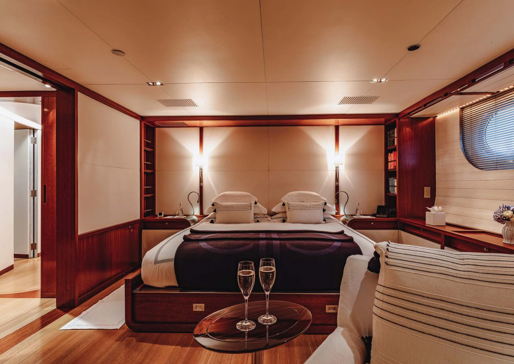 a hotel room with a bed and wine glass aboard ROSEHEARTY Yacht for Charter