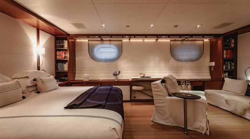a room with a bed and a chair aboard ROSEHEARTY Yacht for Charter