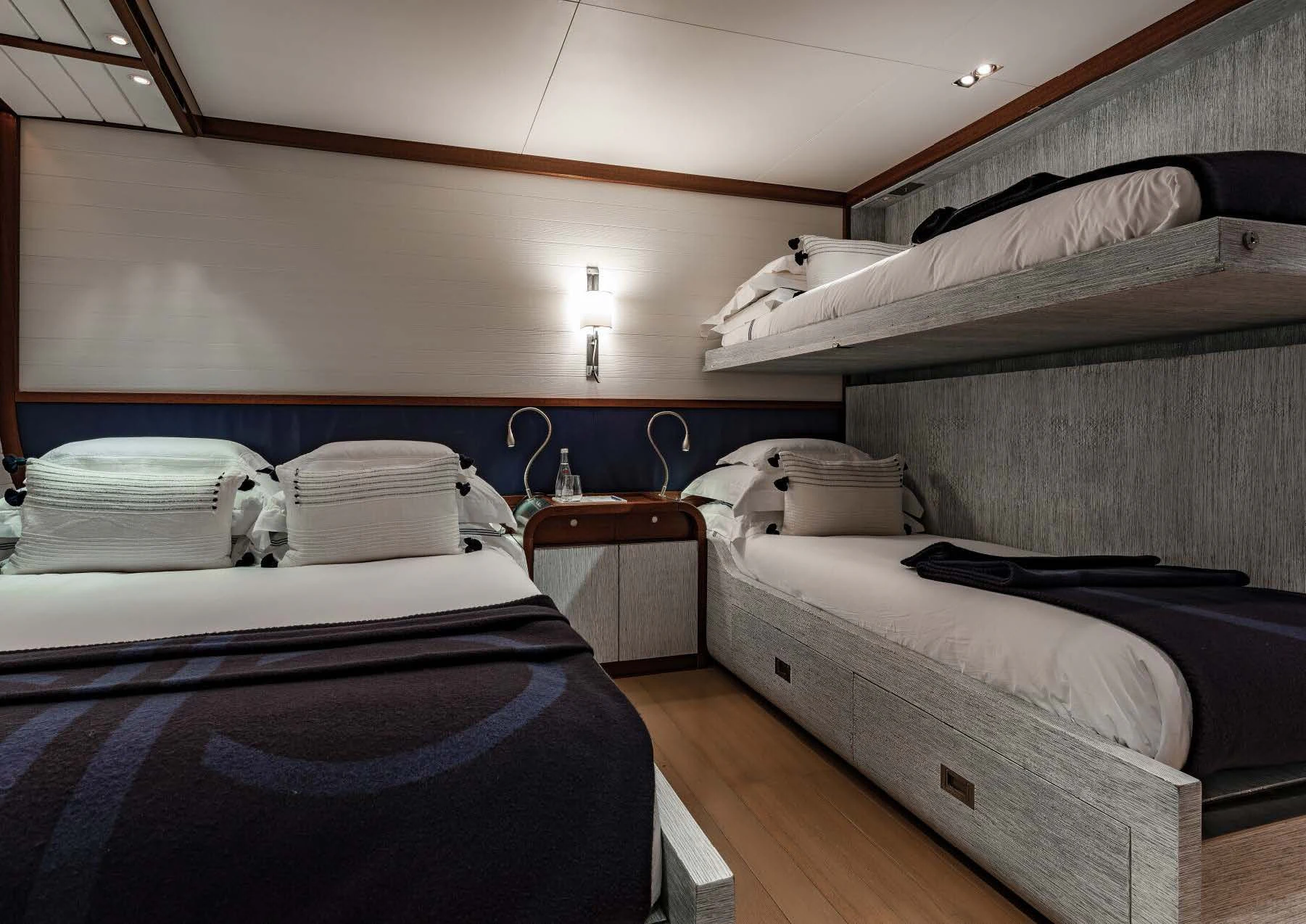 a room with beds and a lamp aboard ROSEHEARTY Yacht for Charter