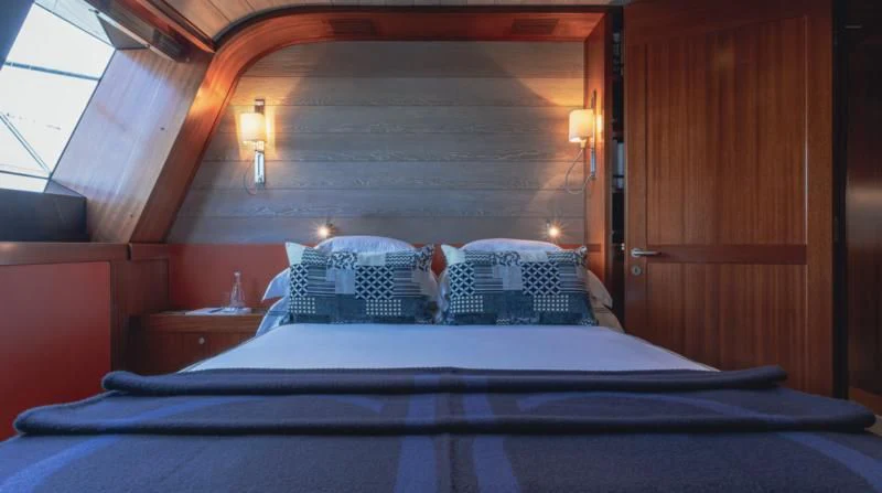 a bed with a blue comforter aboard ROSEHEARTY Yacht for Charter
