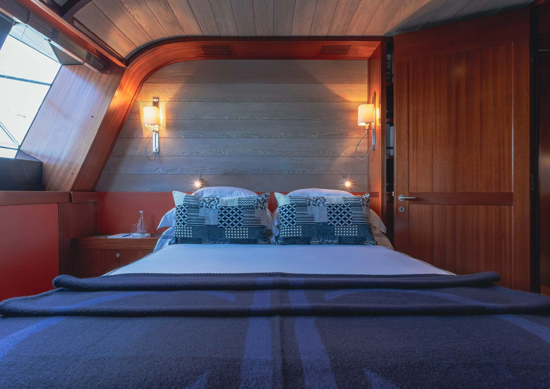 a bed with a blue comforter aboard ROSEHEARTY Yacht for Charter
