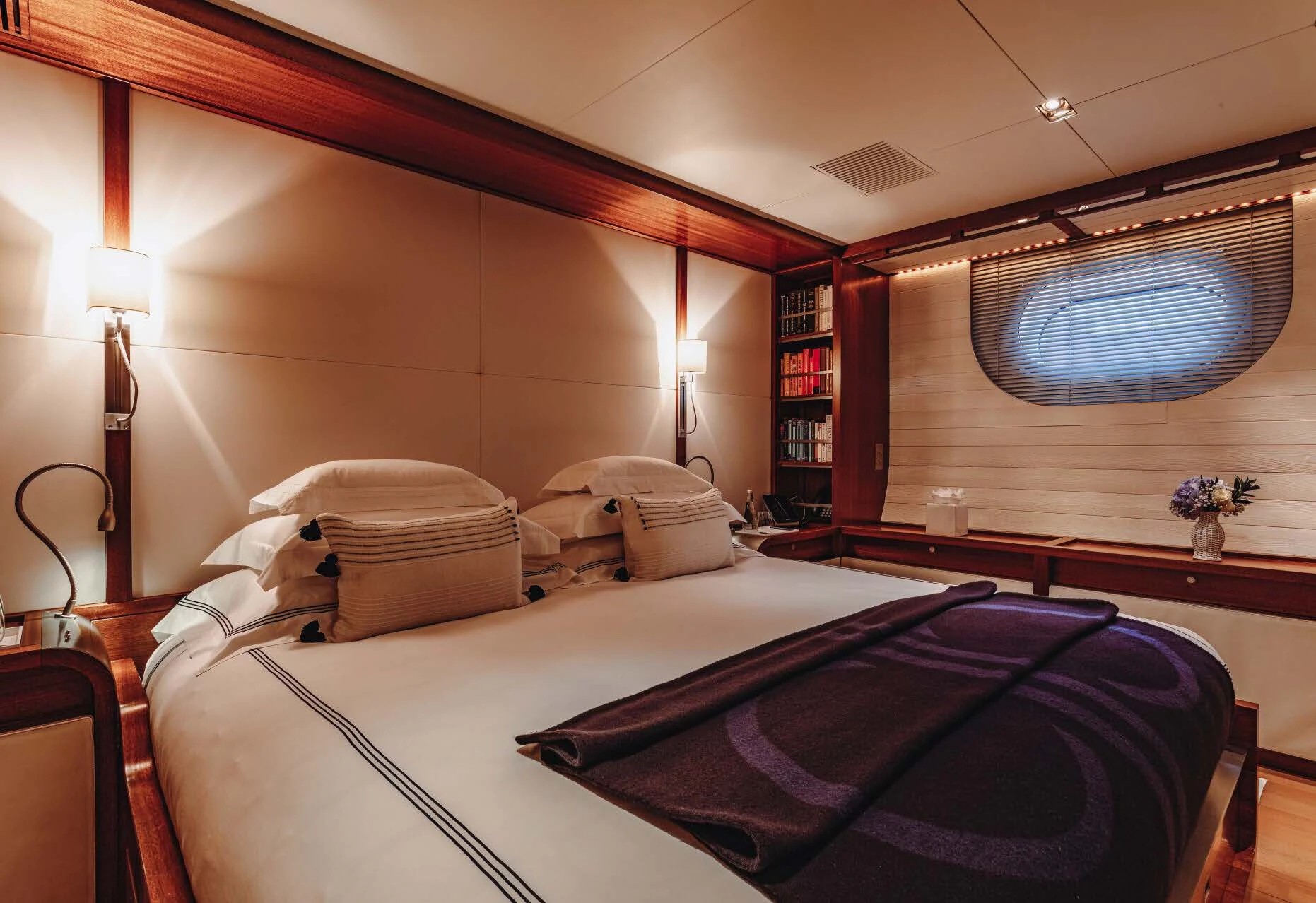 a bedroom with a bed and a bookcase aboard ROSEHEARTY Yacht for Charter
