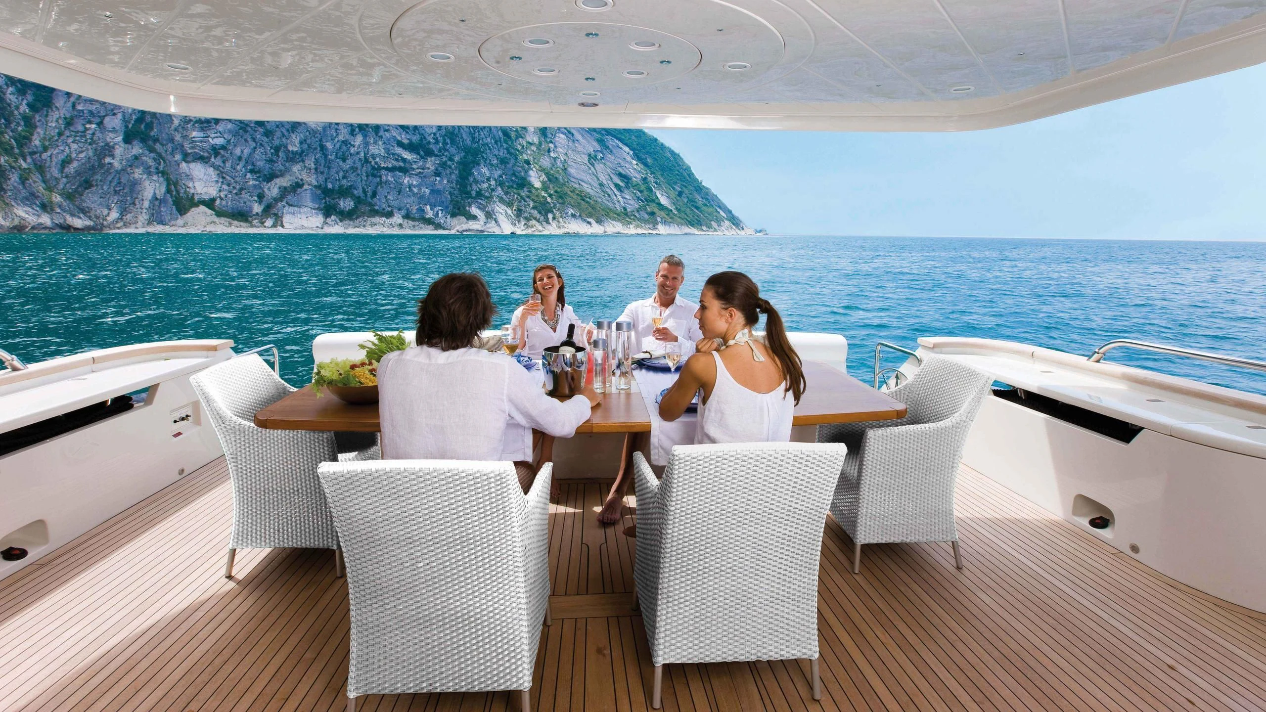 a group of people sitting around a table on a boat aboard NASEEM Yacht for Sale