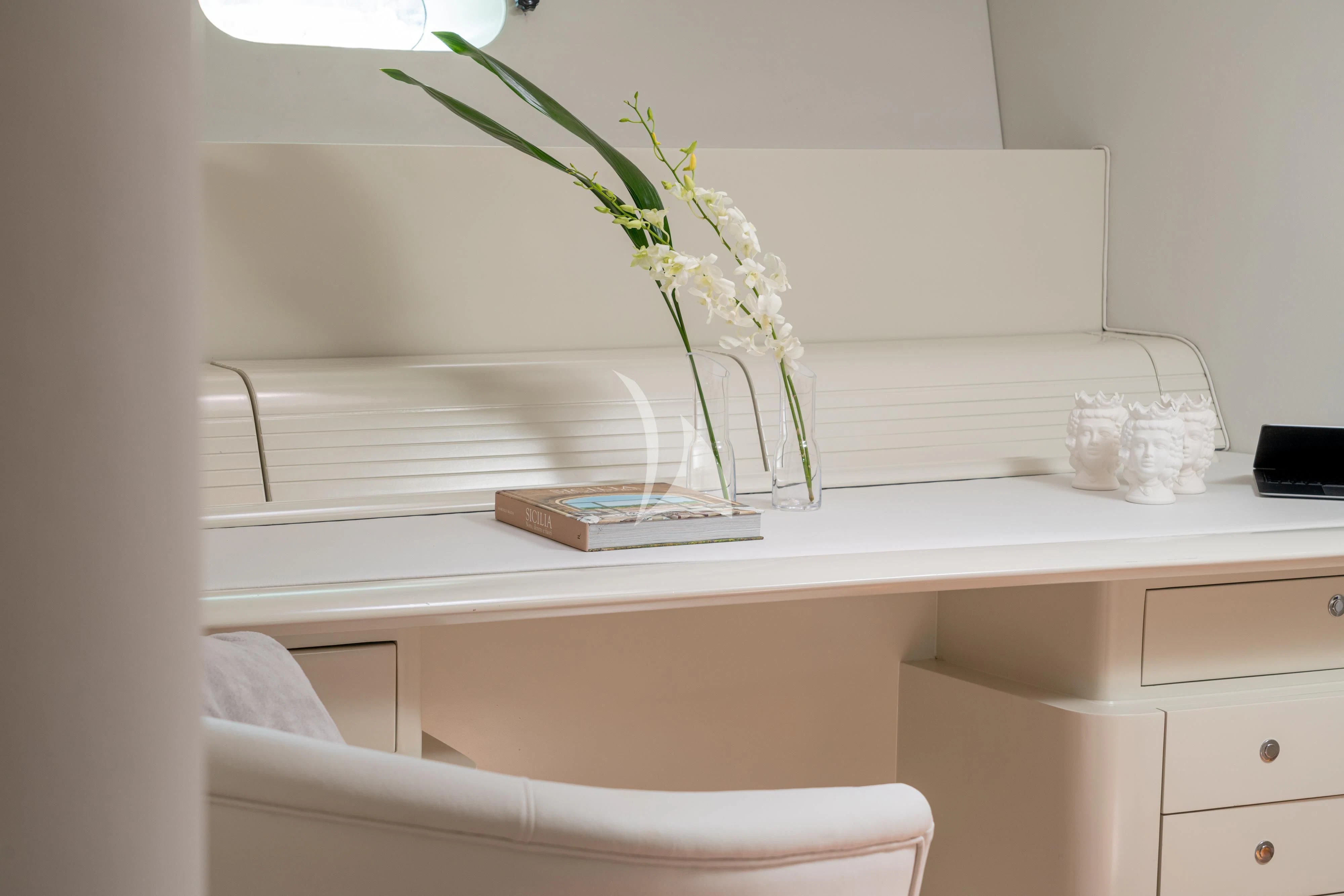 a white desk with a vase of flowers on it aboard ASHLEYROSE Yacht for Sale
