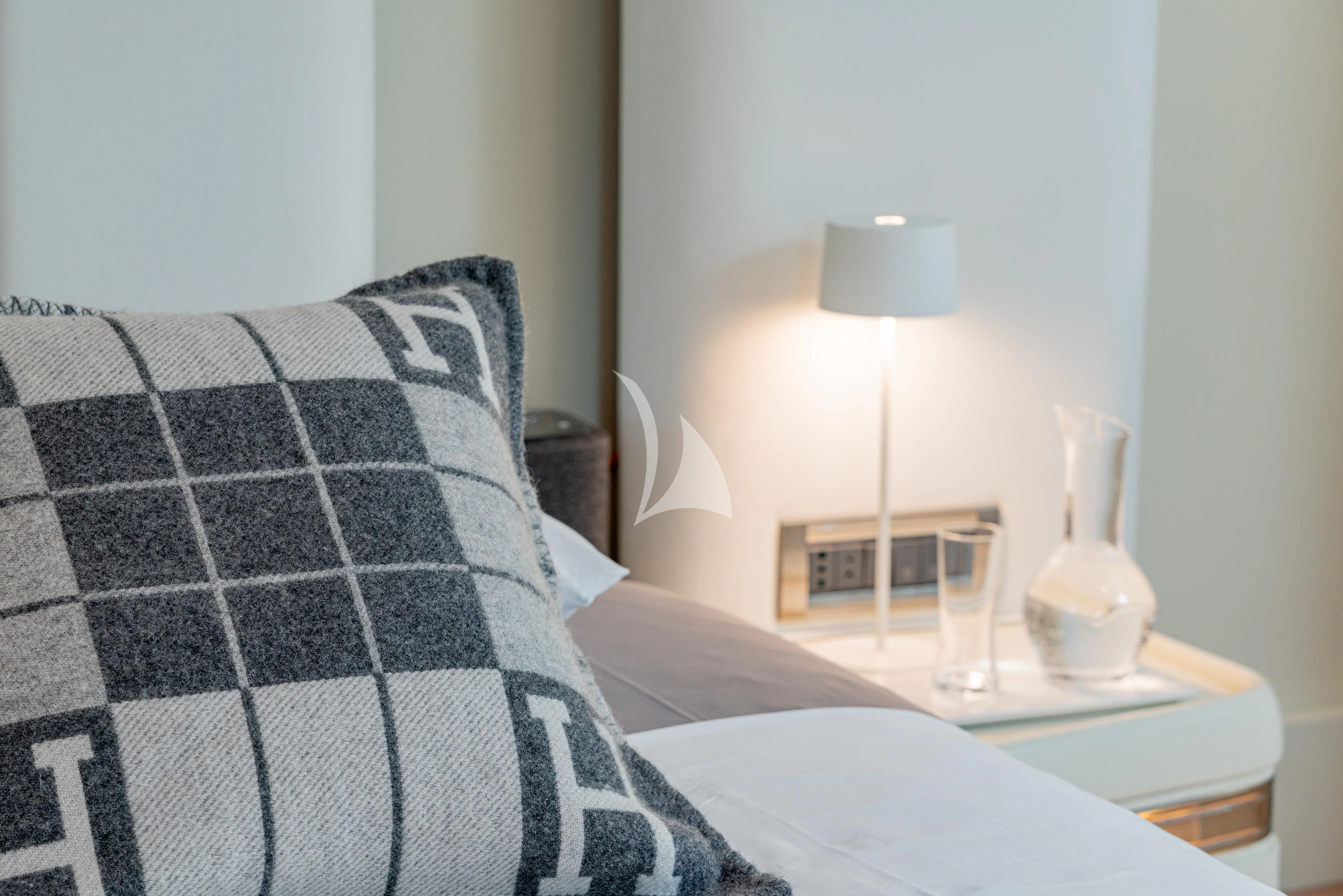 a bed with a lamp and a table with a candle on it aboard ASHLEYROSE Yacht for Sale