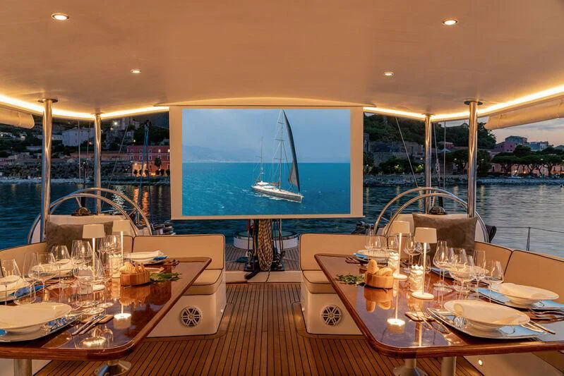 a room with a table and chairs and a large screen aboard ASHLEYROSE Yacht for Sale