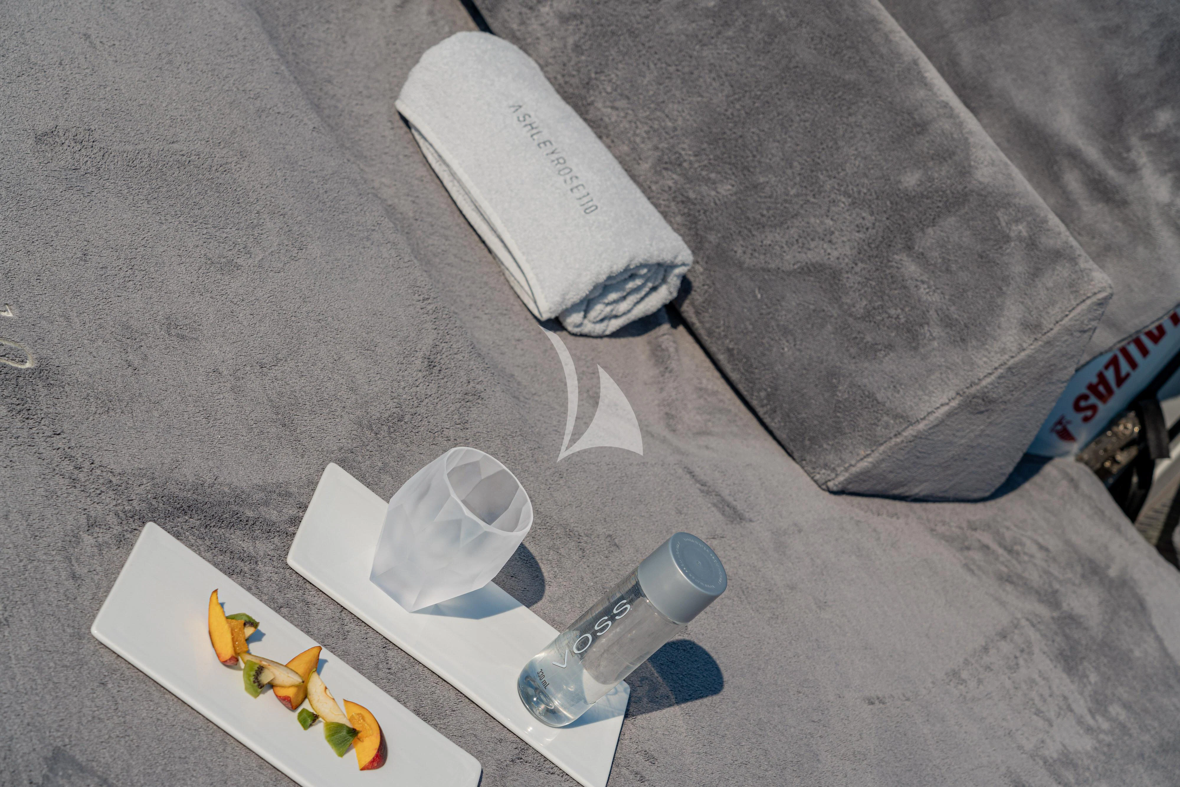 a white plastic toy and a plastic water bottle on a concrete surface aboard ASHLEYROSE Yacht for Sale