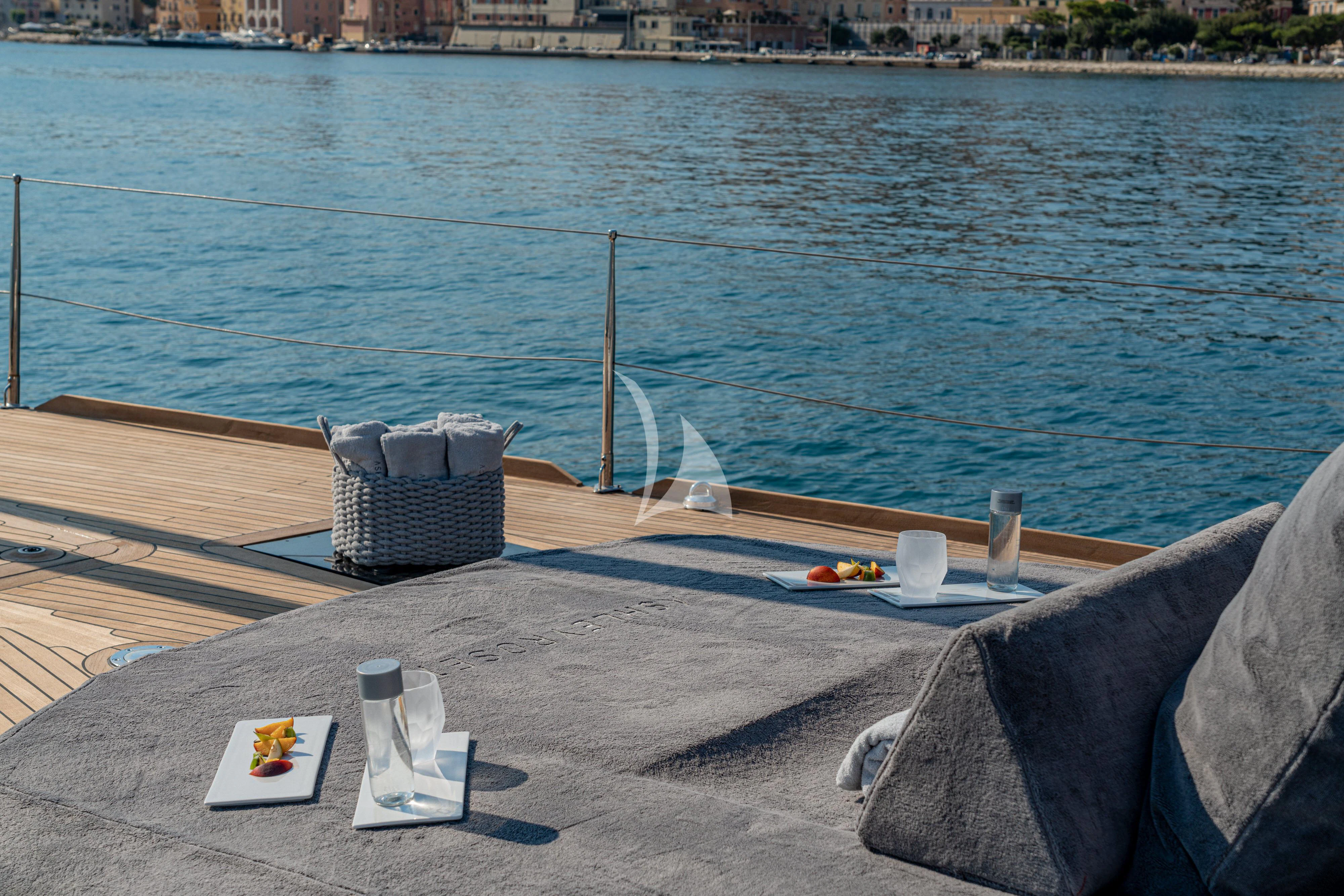 a table on a deck overlooking a body of water aboard ASHLEYROSE Yacht for Sale