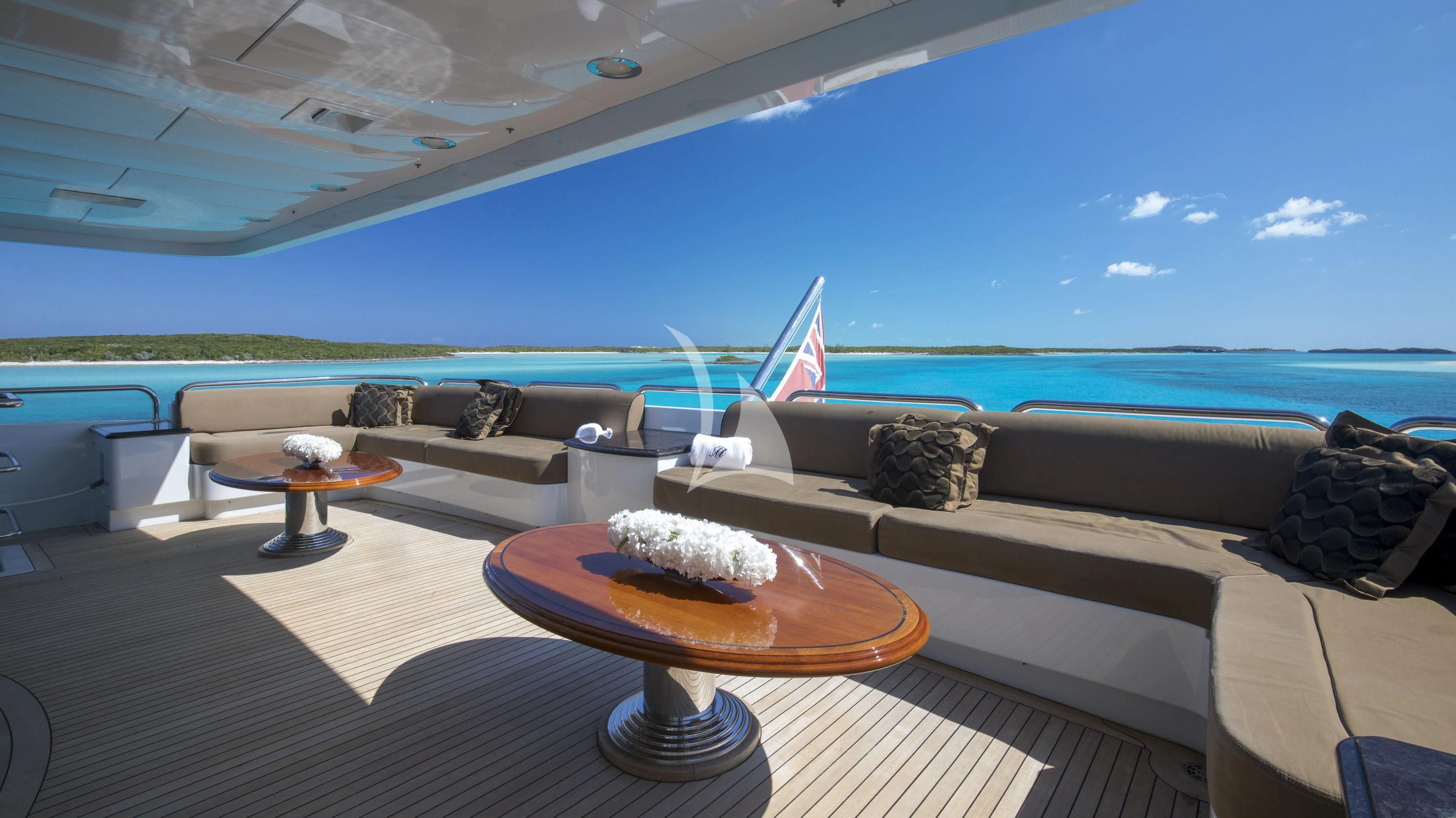 a lounge area with a couch and a table with a flag on it aboard MILESTONE Yacht for Sale