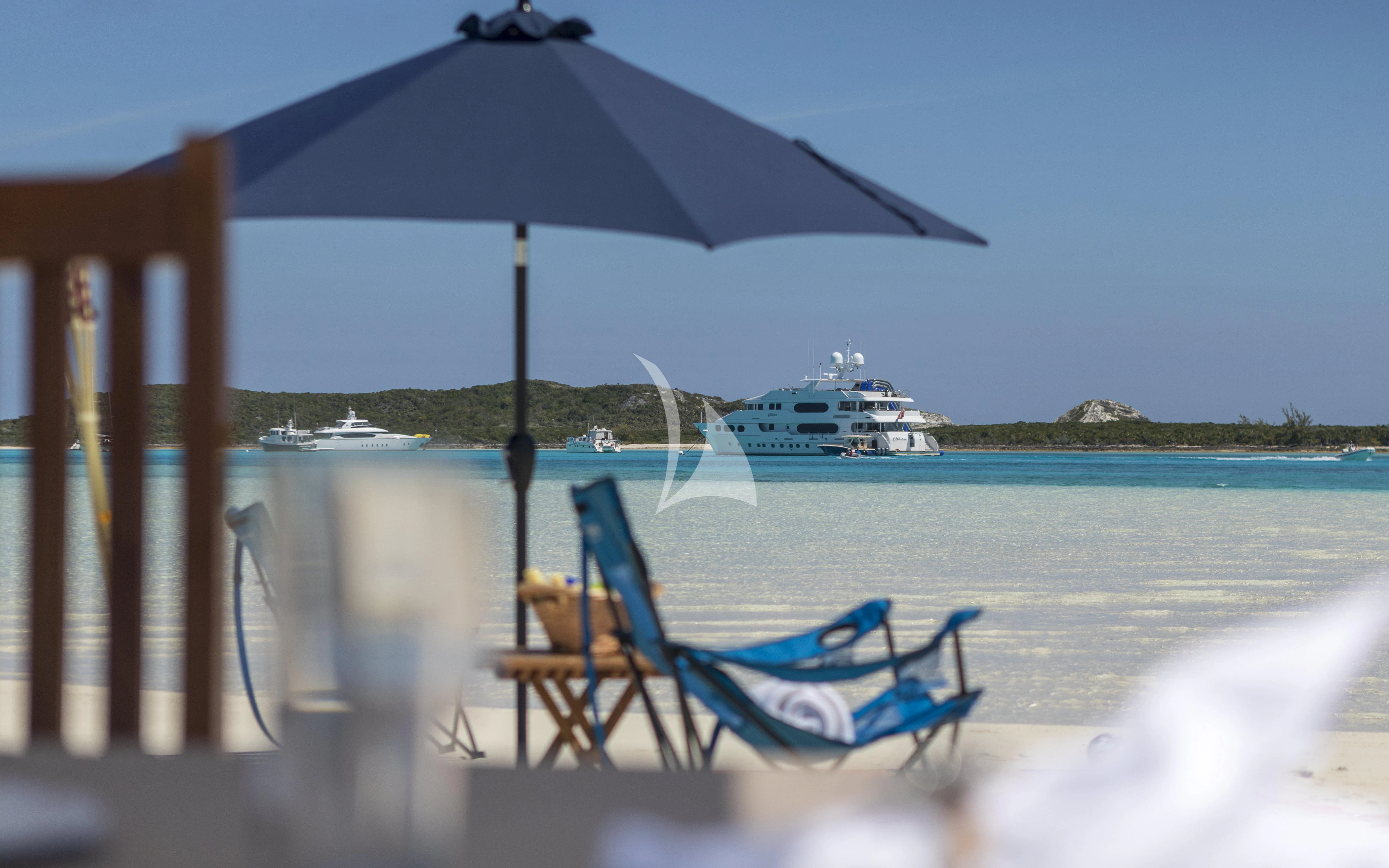 a chair and umbrella on a beach aboard MILESTONE Yacht for Sale