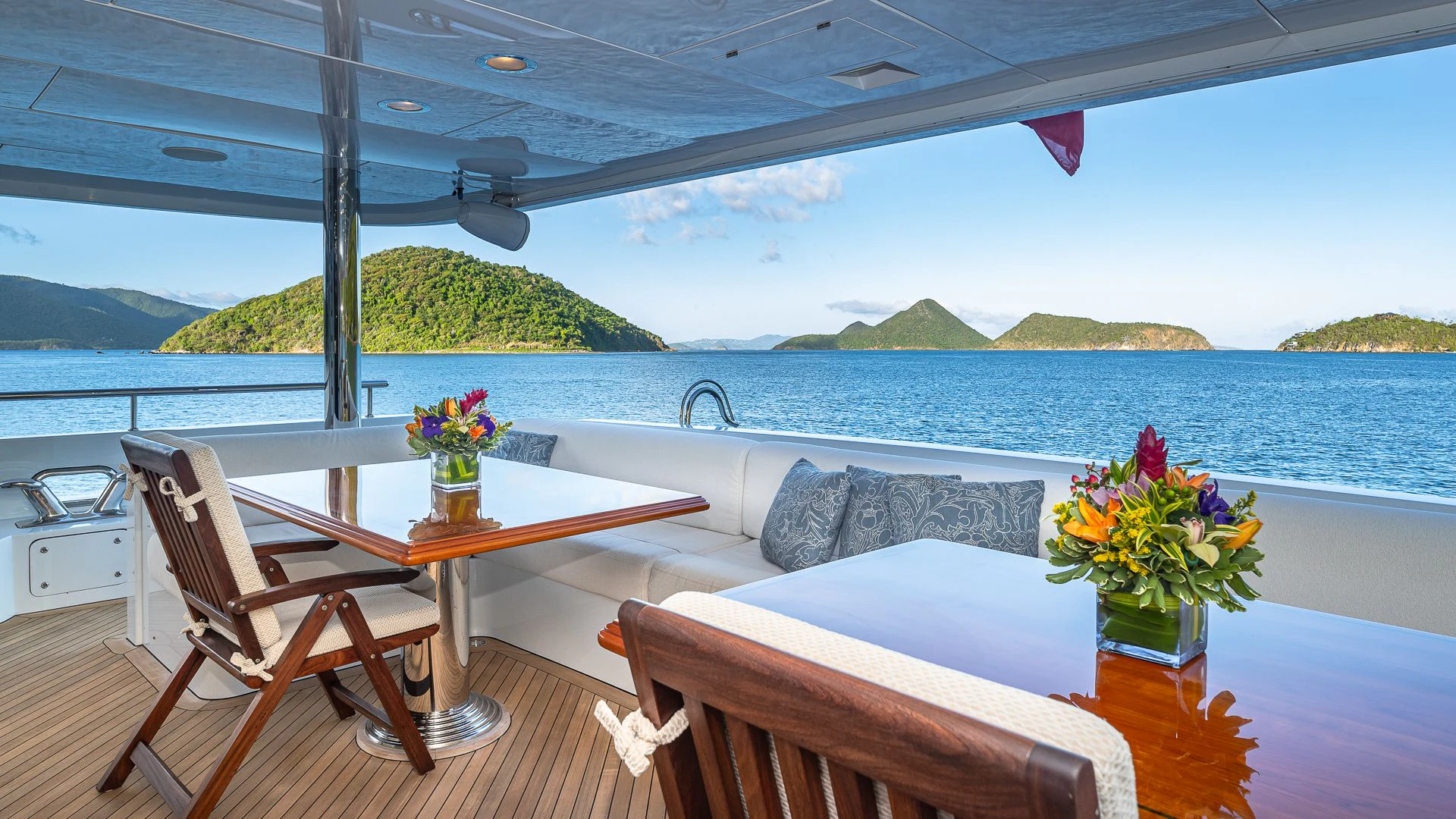 a table and chairs on a deck overlooking a body of water aboard MILESTONE Yacht for Sale