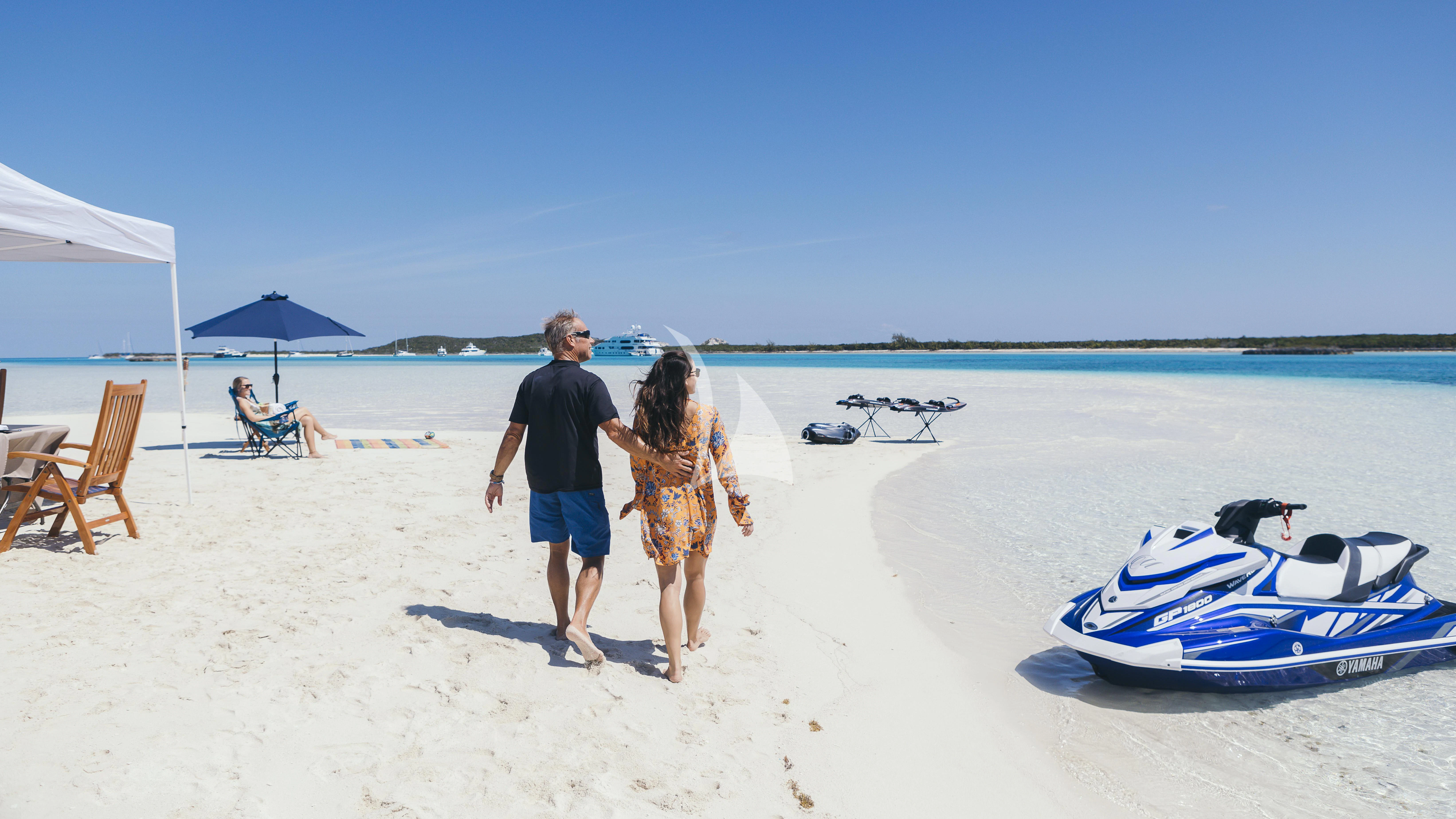 a person and a girl walking on a beach aboard MILESTONE Yacht for Sale