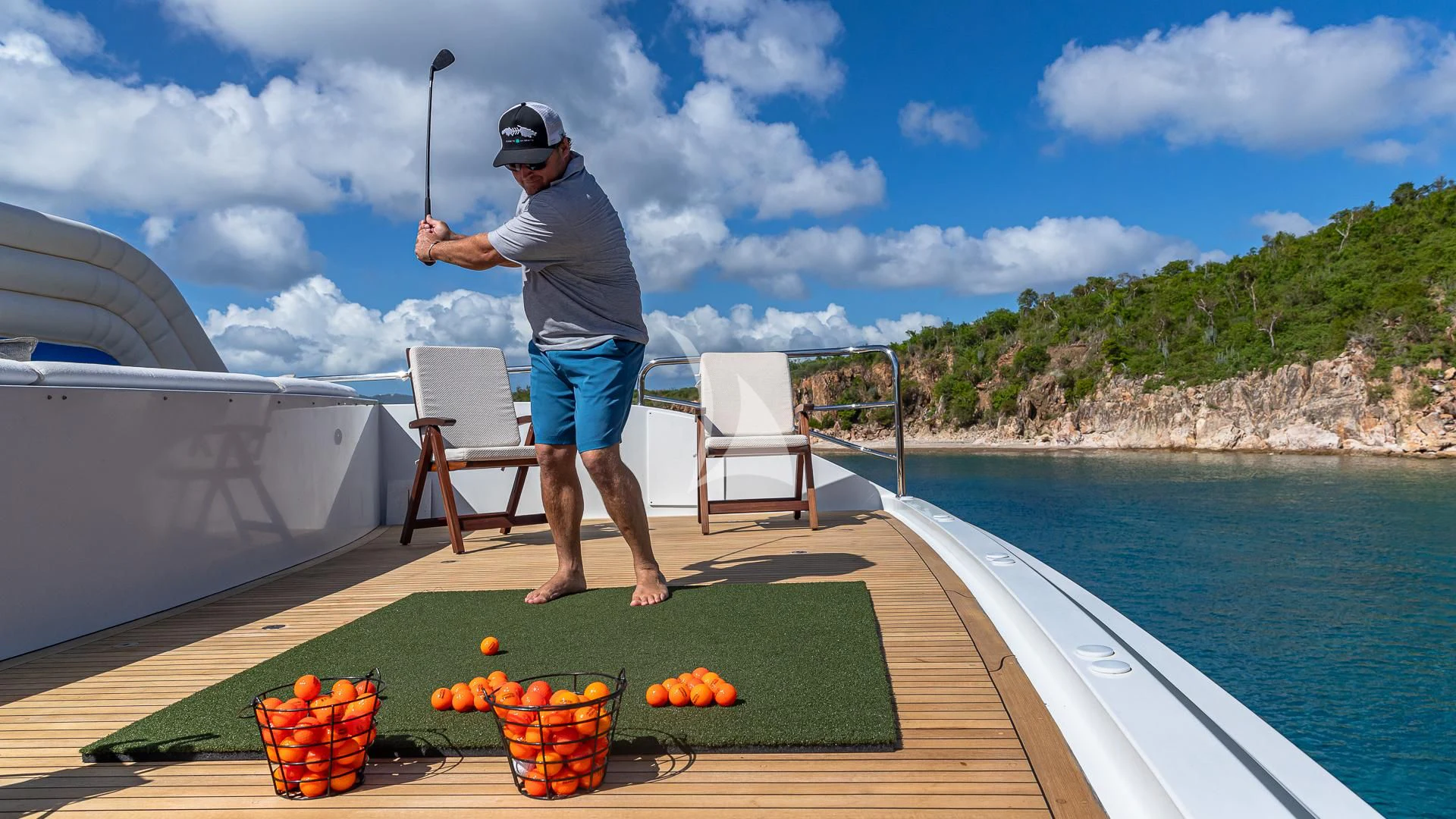 a man standing on a deck near a pool of fruit aboard MILESTONE Yacht for Sale