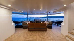 a room with a couch and a large blue pool aboard ALASKA Yacht for Sale