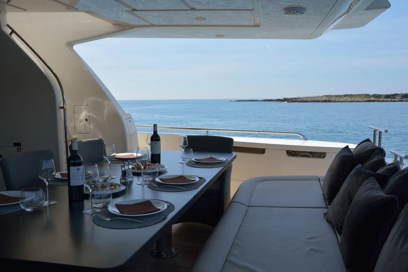 a table with plates and wine bottles on it aboard HEAL Yacht for Sale