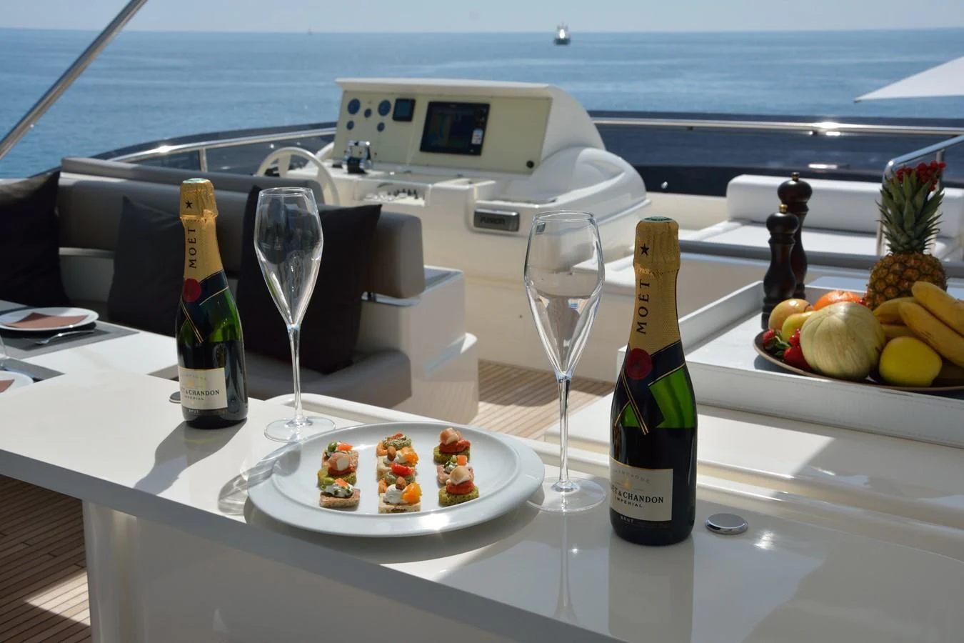 a bottle of wine next to a plate of dessert on a table aboard HEAL Yacht for Sale
