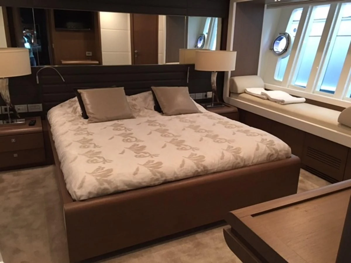 a bed with a white comforter aboard HEAL Yacht for Sale