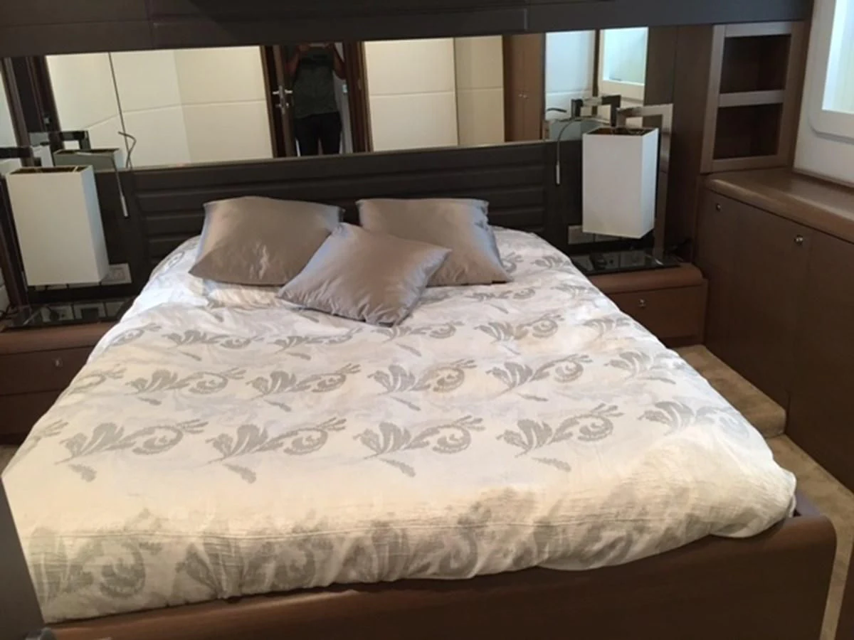 a bed with white sheets aboard HEAL Yacht for Sale