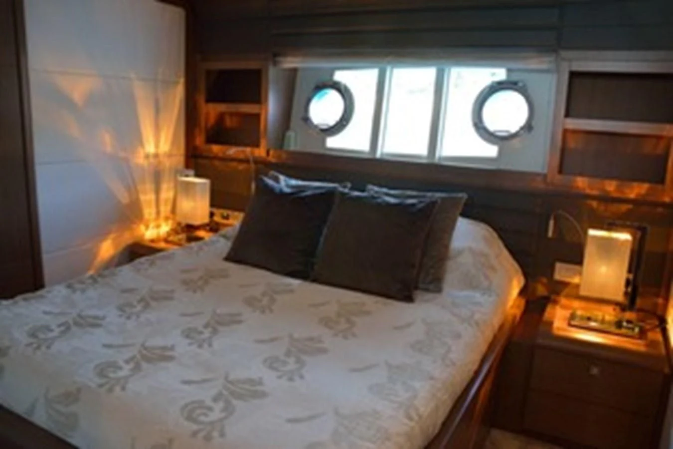 a bed with a white comforter aboard HEAL Yacht for Sale