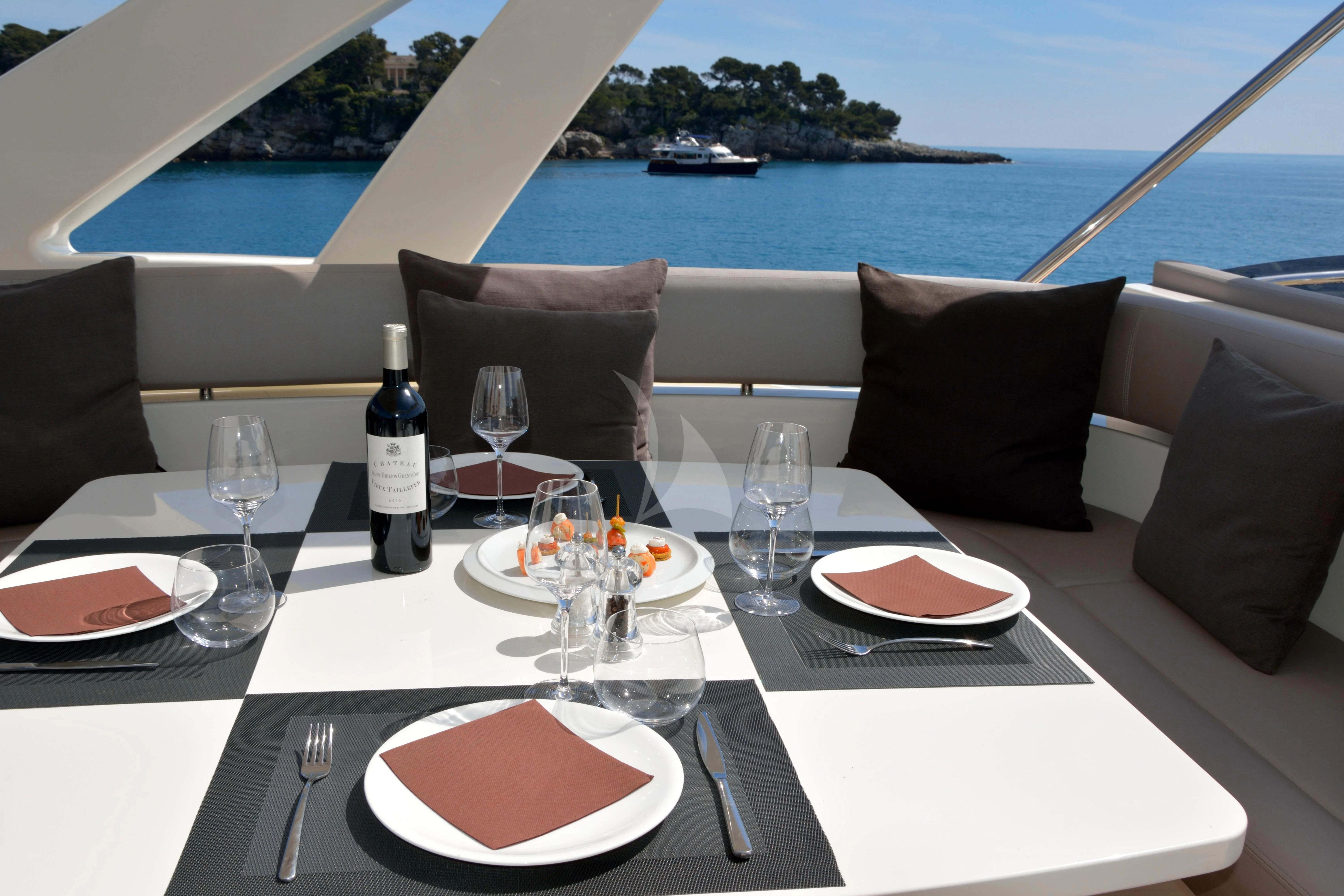 a table with plates and wine bottles on it aboard HEAL Yacht for Sale