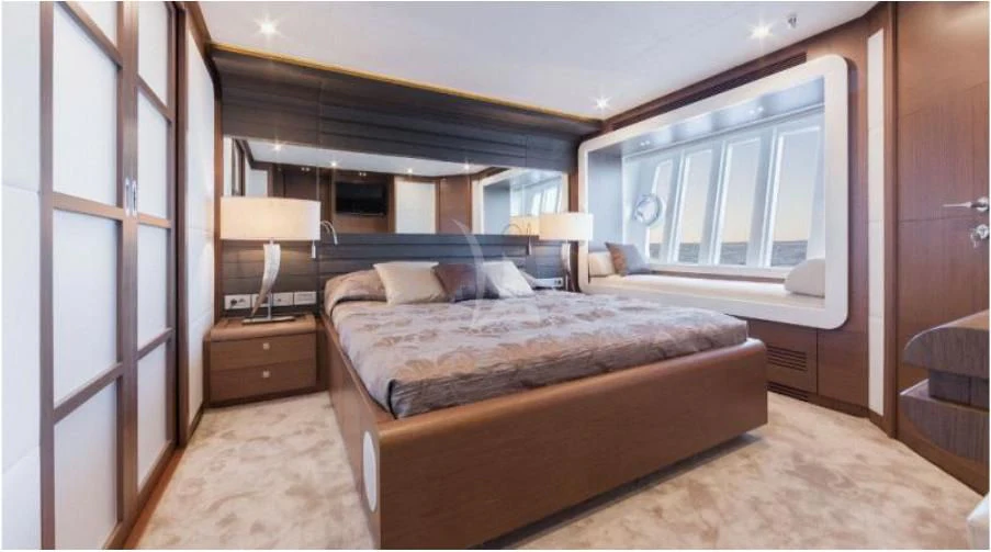 a bedroom with a bed and a lamp aboard HEAL Yacht for Sale