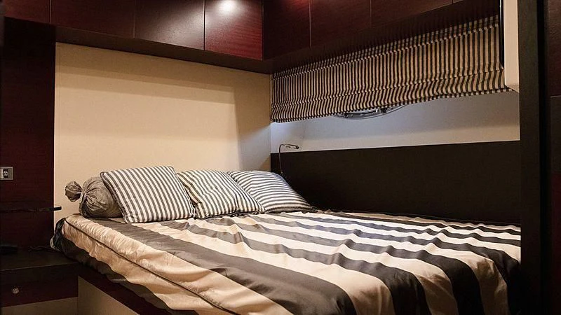 a bed with a striped sheet aboard ALDA 2 Yacht for Sale