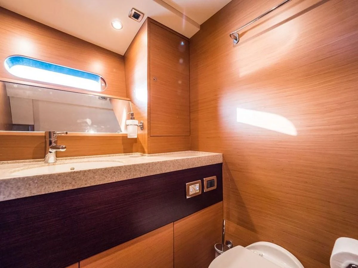 a bathroom with a countertop sink and wooden cabinets aboard KALINDA Yacht for Sale