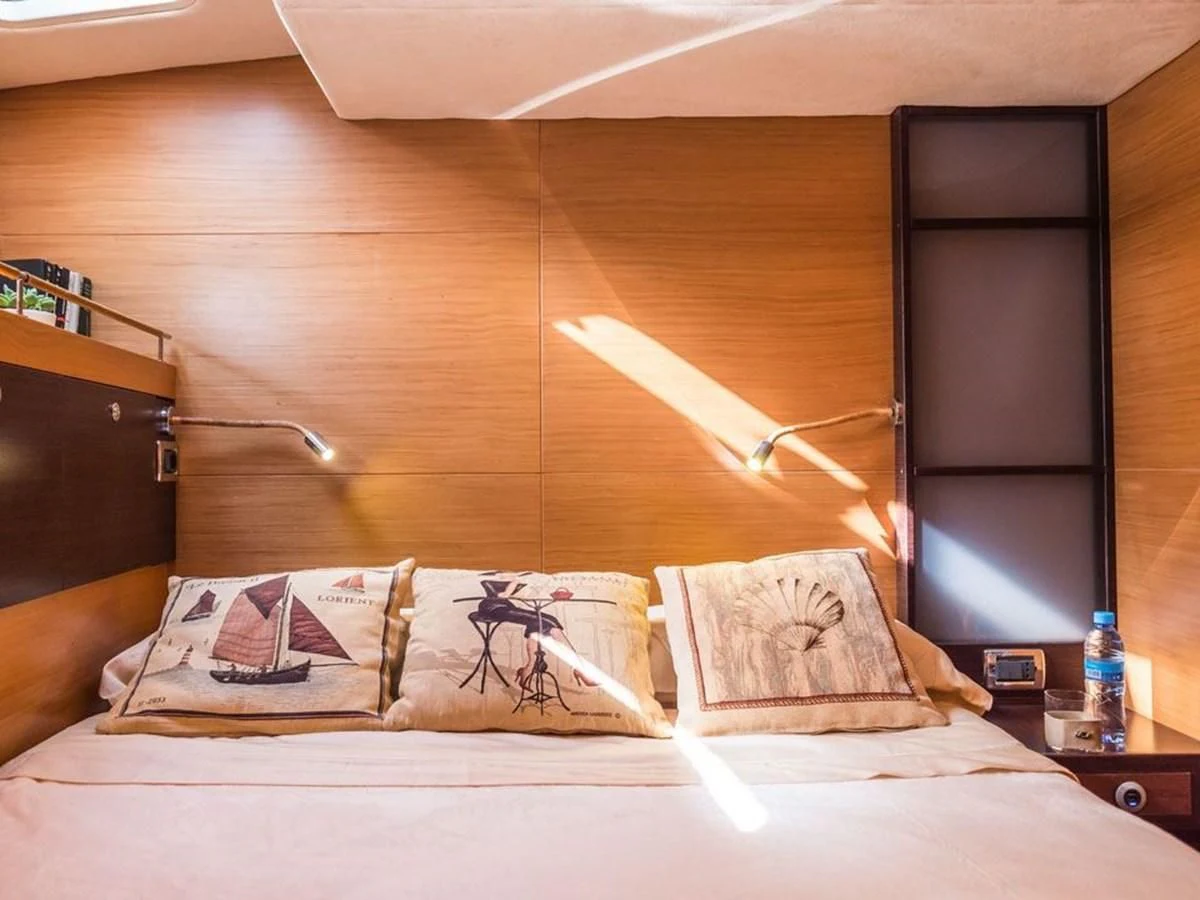 a bed with a white sheet and pillows aboard KALINDA Yacht for Sale