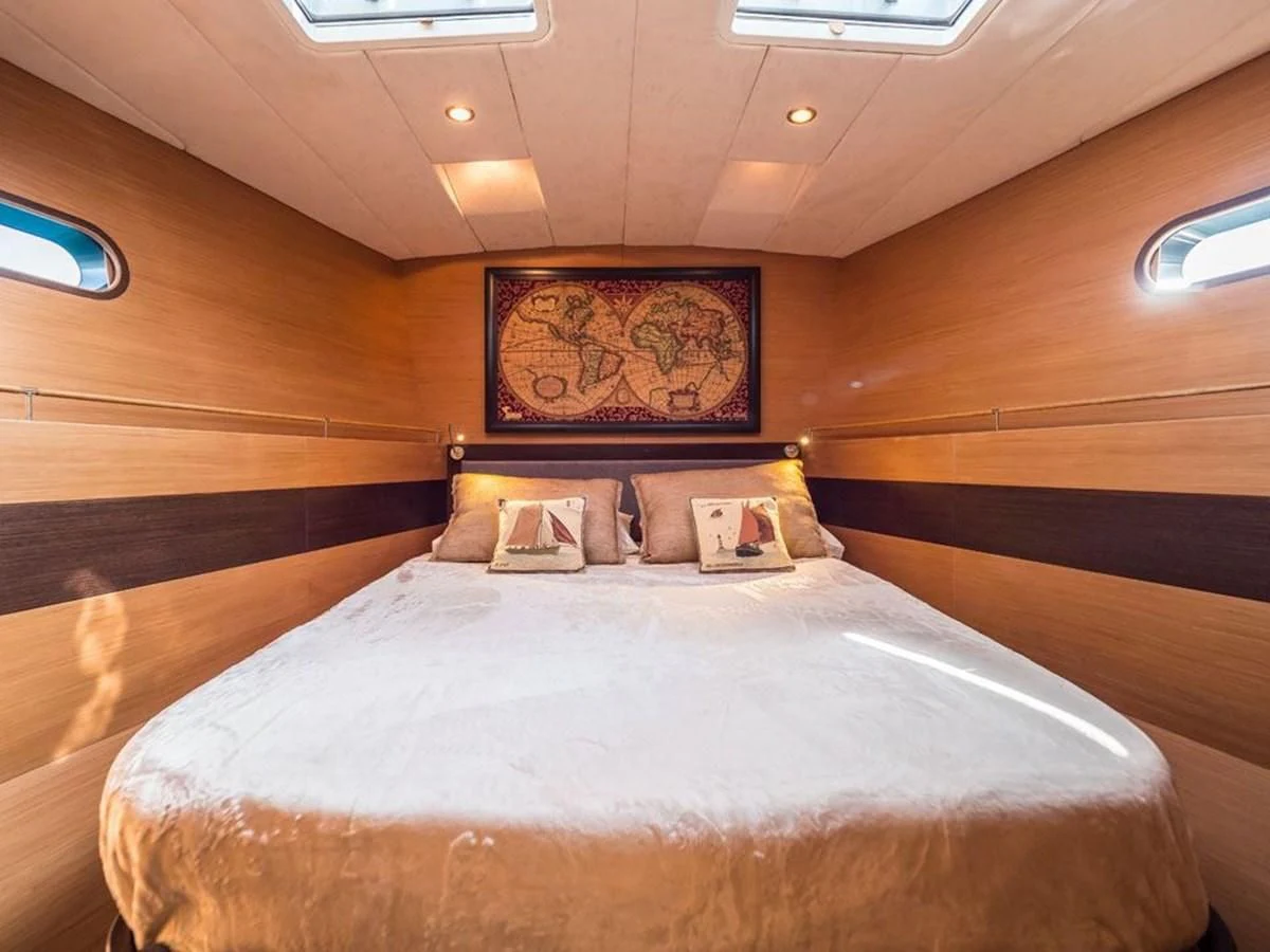 a bed with a painting on the wall aboard KALINDA Yacht for Sale