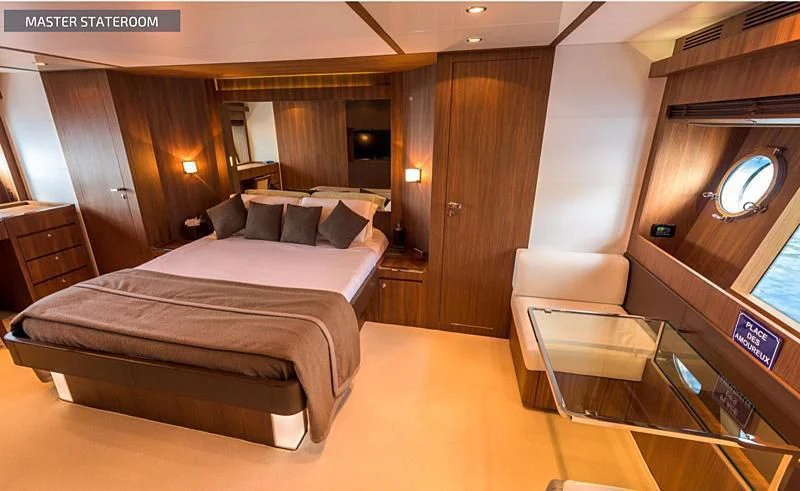 a room with a bed and a chair aboard RUFF ONE II Yacht for Sale