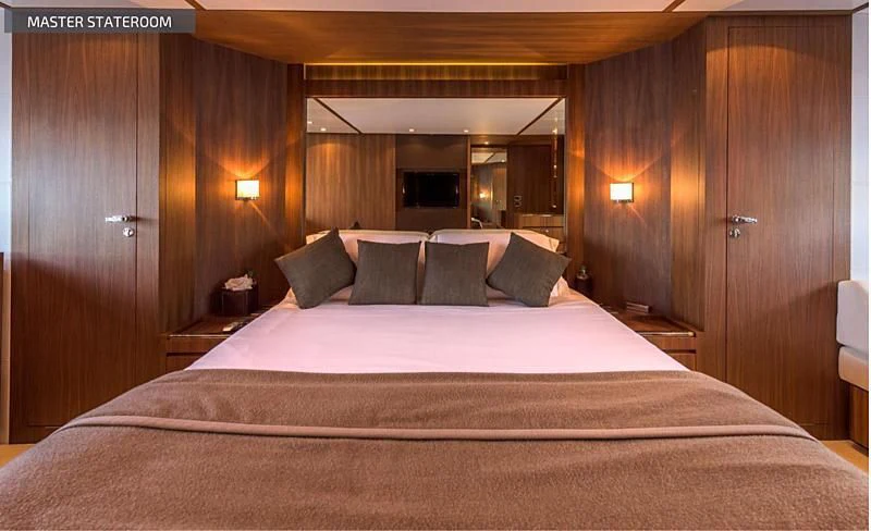 a bed with a white sheet and pillows on it aboard RUFF ONE II Yacht for Sale