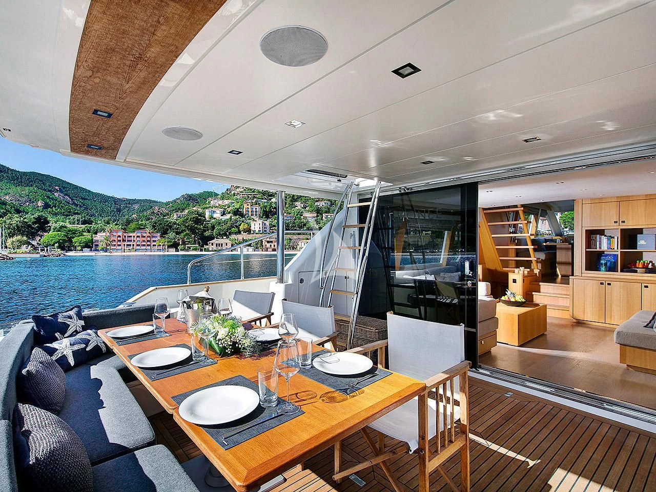 a dining table in a room with a view of the water and mountains aboard ARMONEE Yacht for Sale