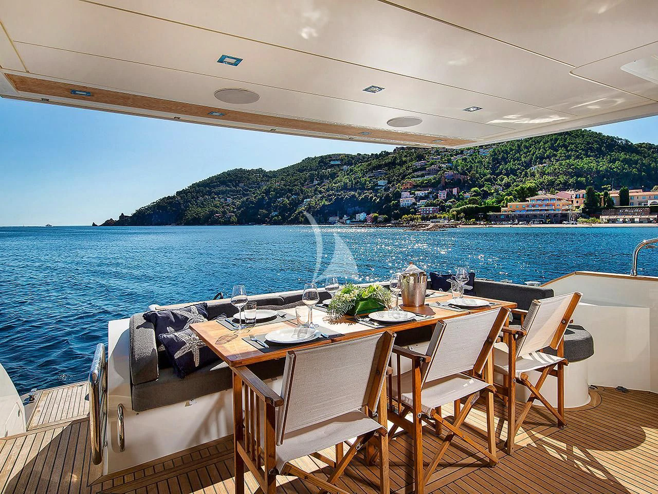 a table set for a meal on a deck overlooking a large body of water aboard ARMONEE Yacht for Sale
