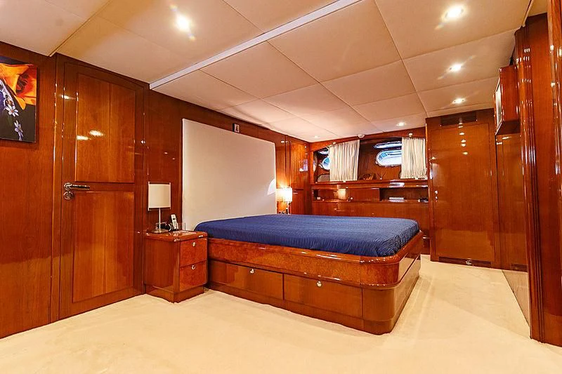 a bedroom with a bed and a desk aboard THEION Yacht for Sale