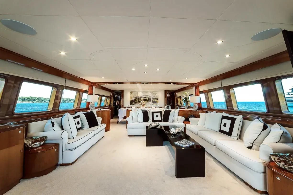 a large white room with a white couch and a large window aboard THEION Yacht for Sale