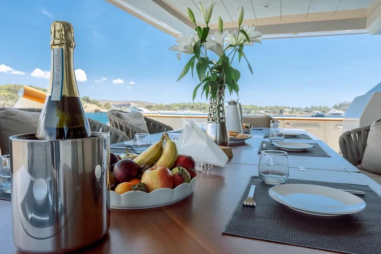 a table with food and a bottle of wine on it aboard THEION Yacht for Sale