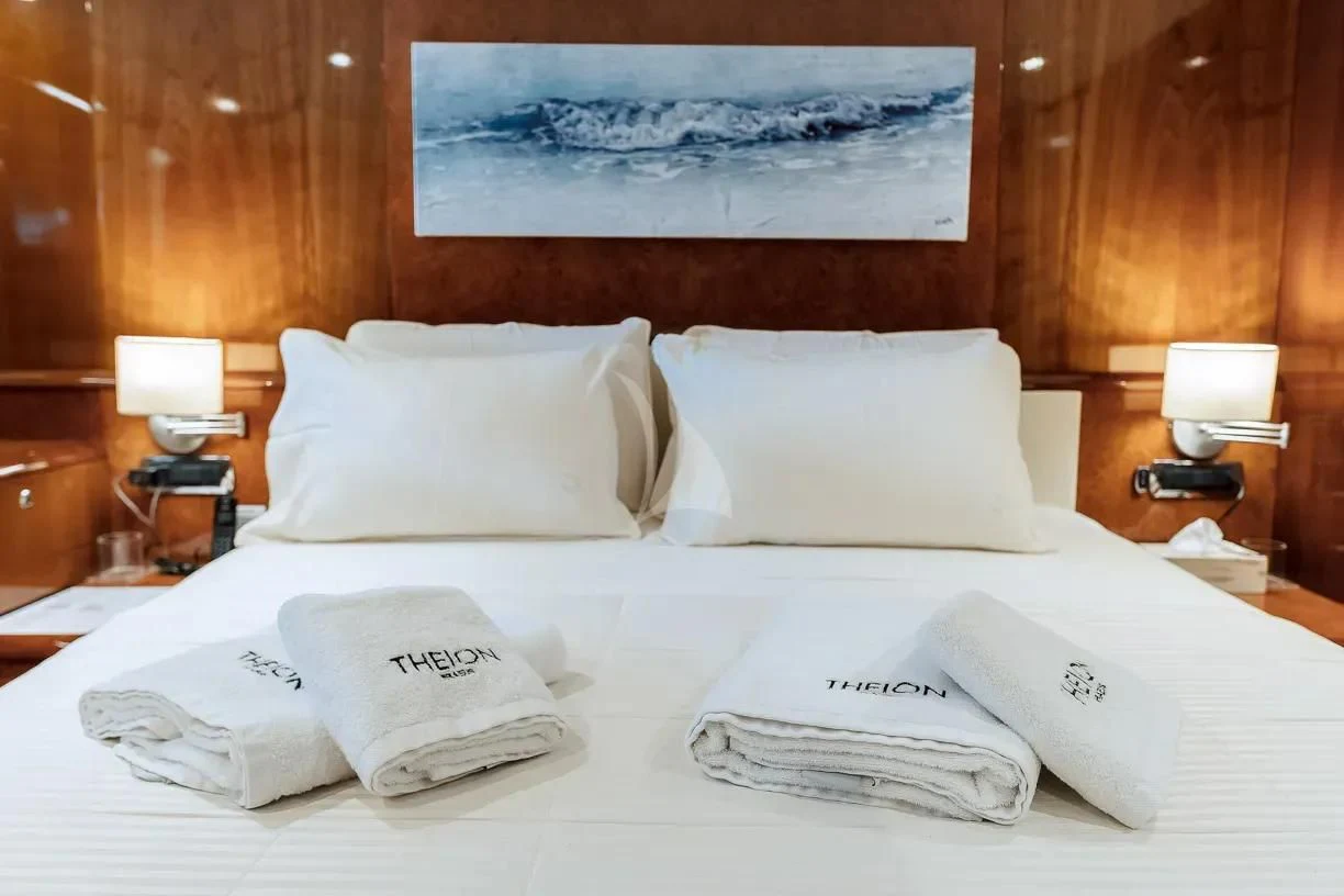 a bed with pillows and a painting aboard THEION Yacht for Sale
