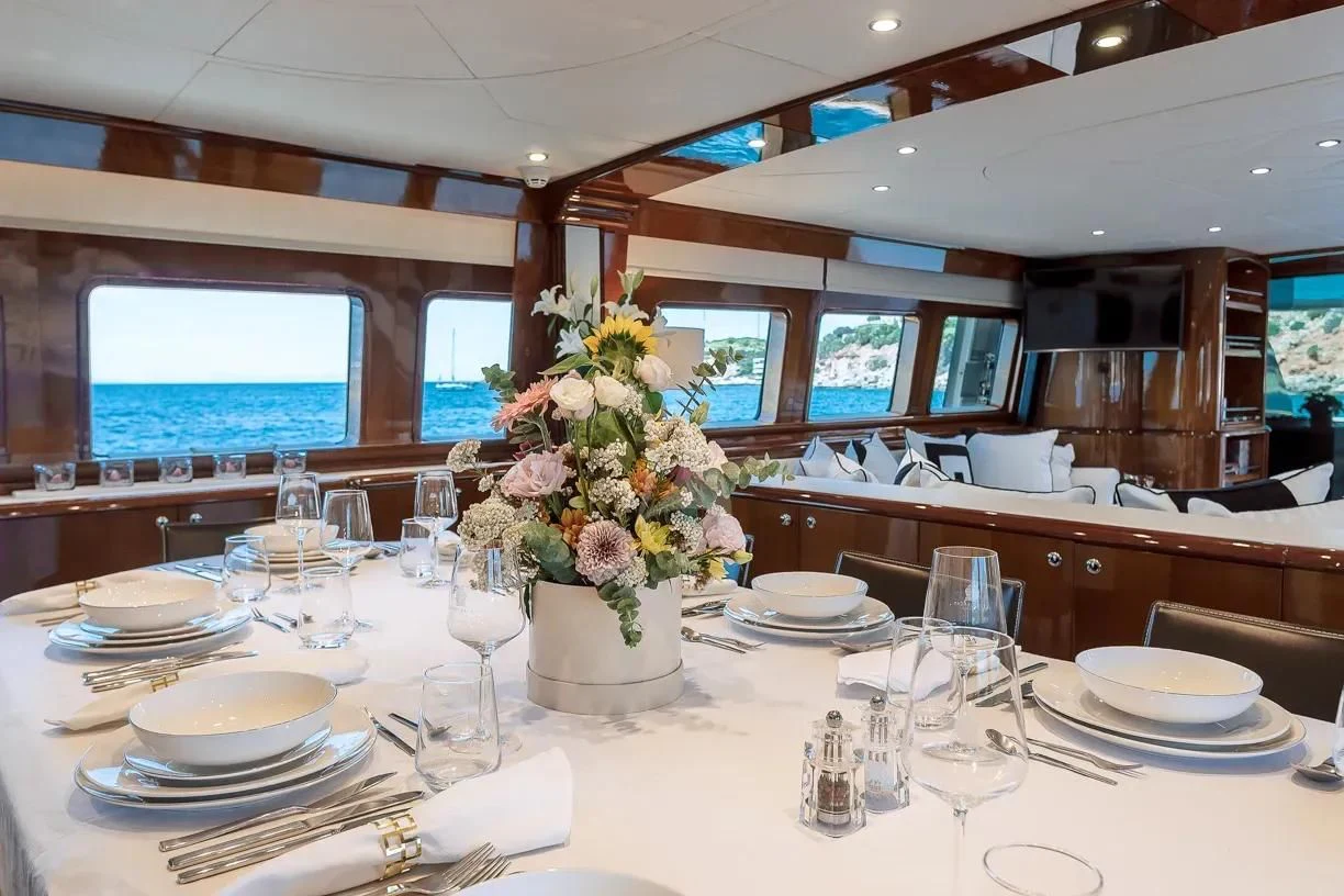 a table set with plates and glasses aboard THEION Yacht for Sale