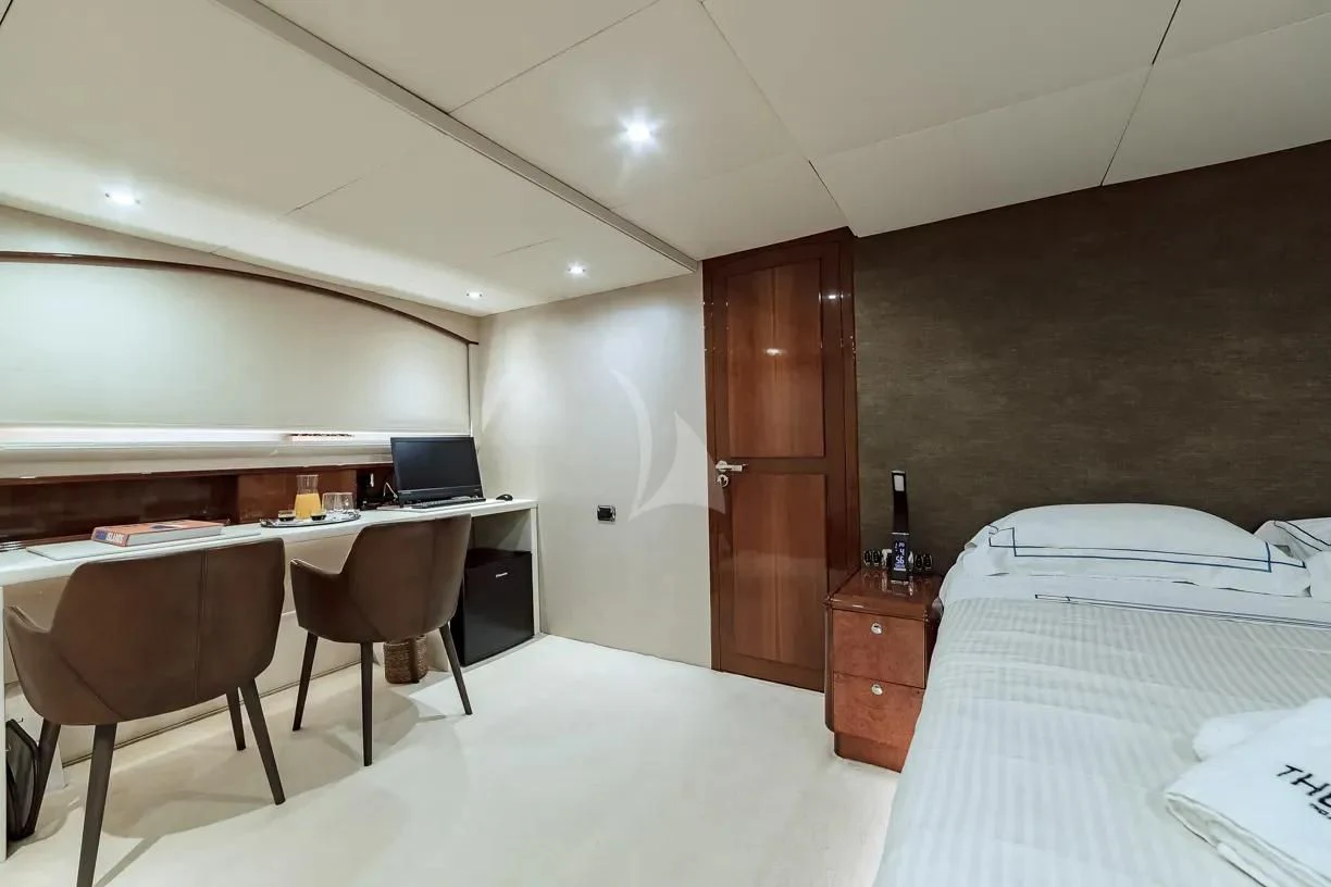 a room with a bed and desk aboard THEION Yacht for Sale