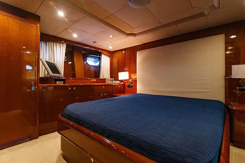 a bedroom with a bed and a desk aboard THEION Yacht for Sale
