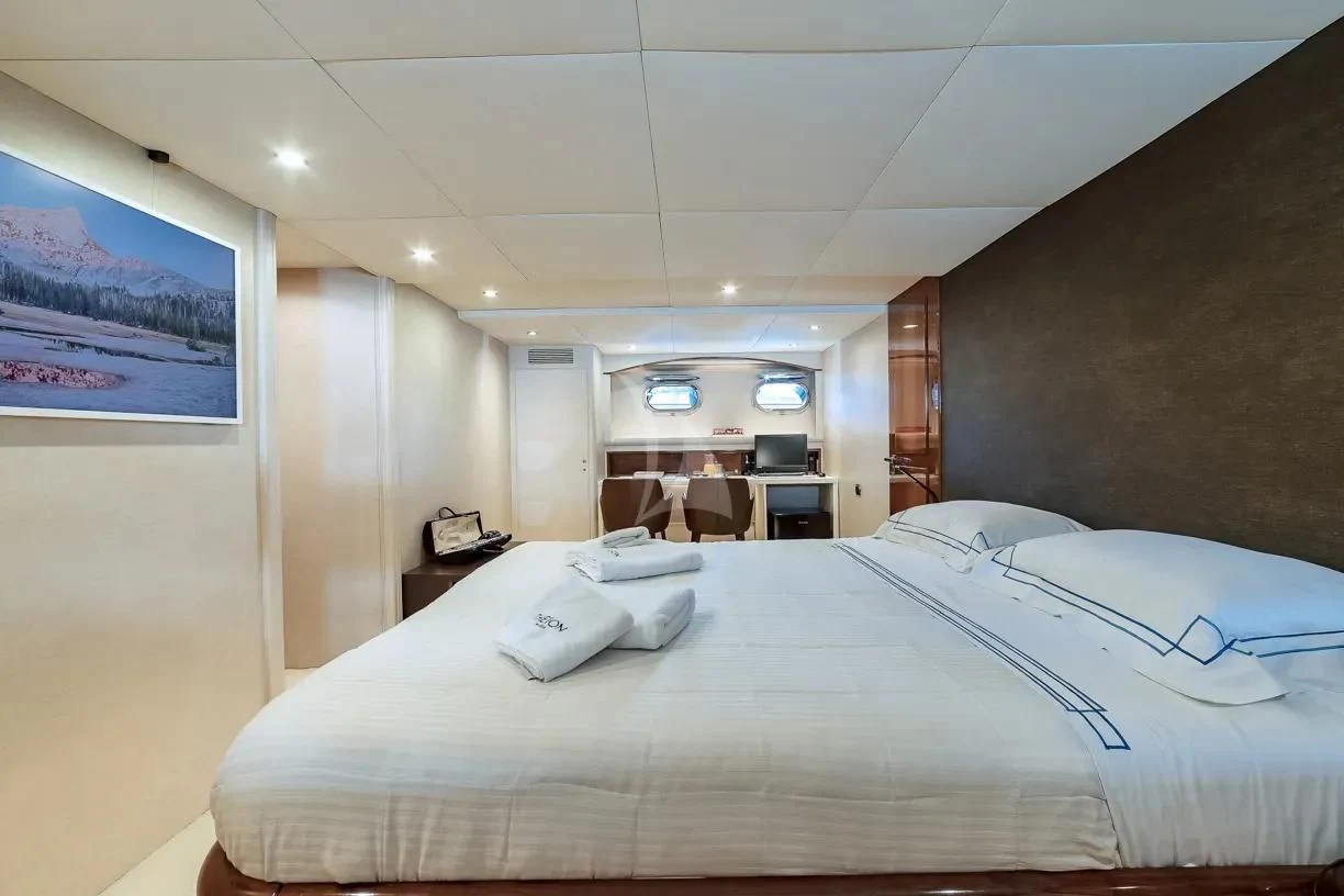 a bedroom with a bed and a chair aboard THEION Yacht for Sale