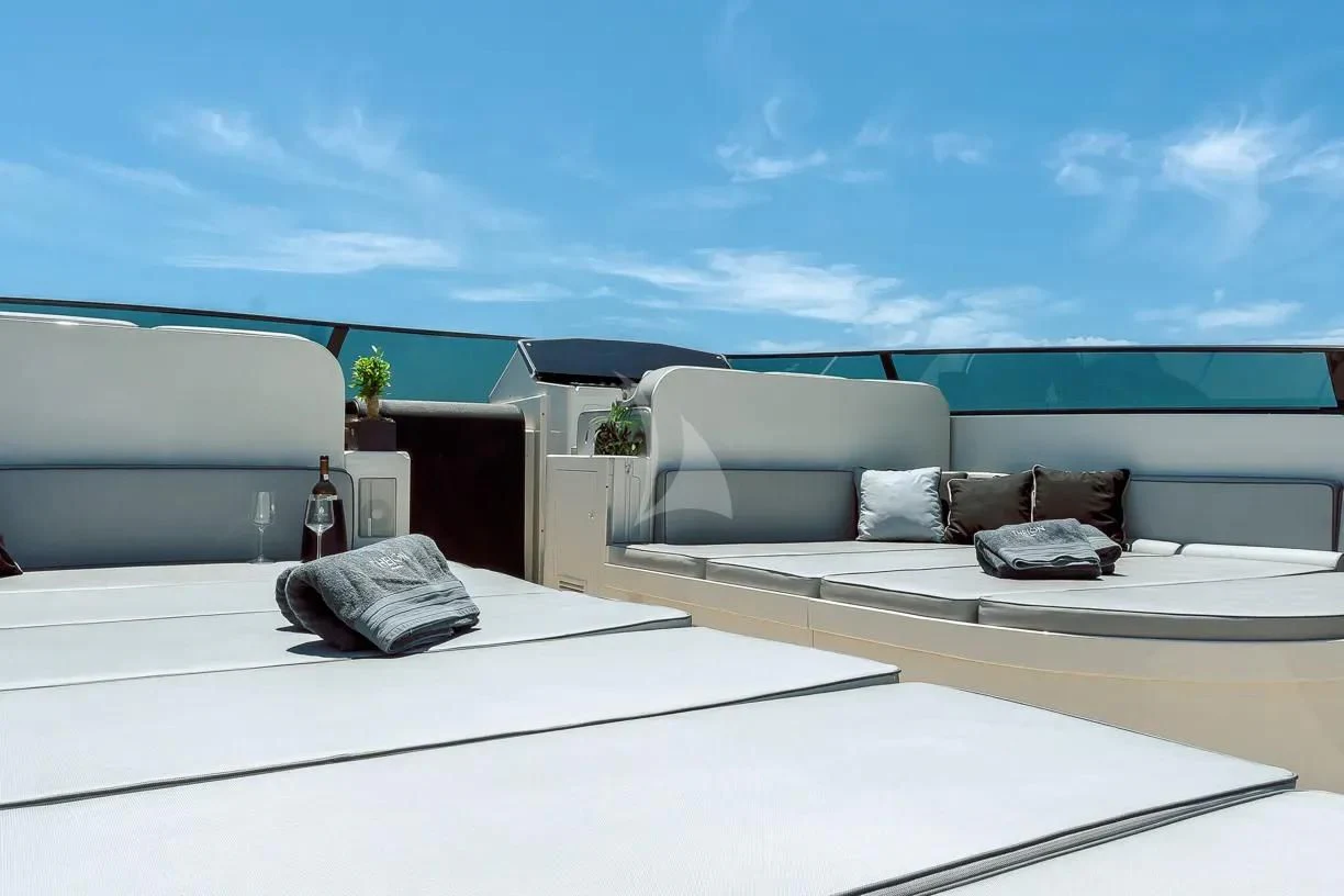 a white couch with pillows on a white surface with a blue sky aboard THEION Yacht for Sale