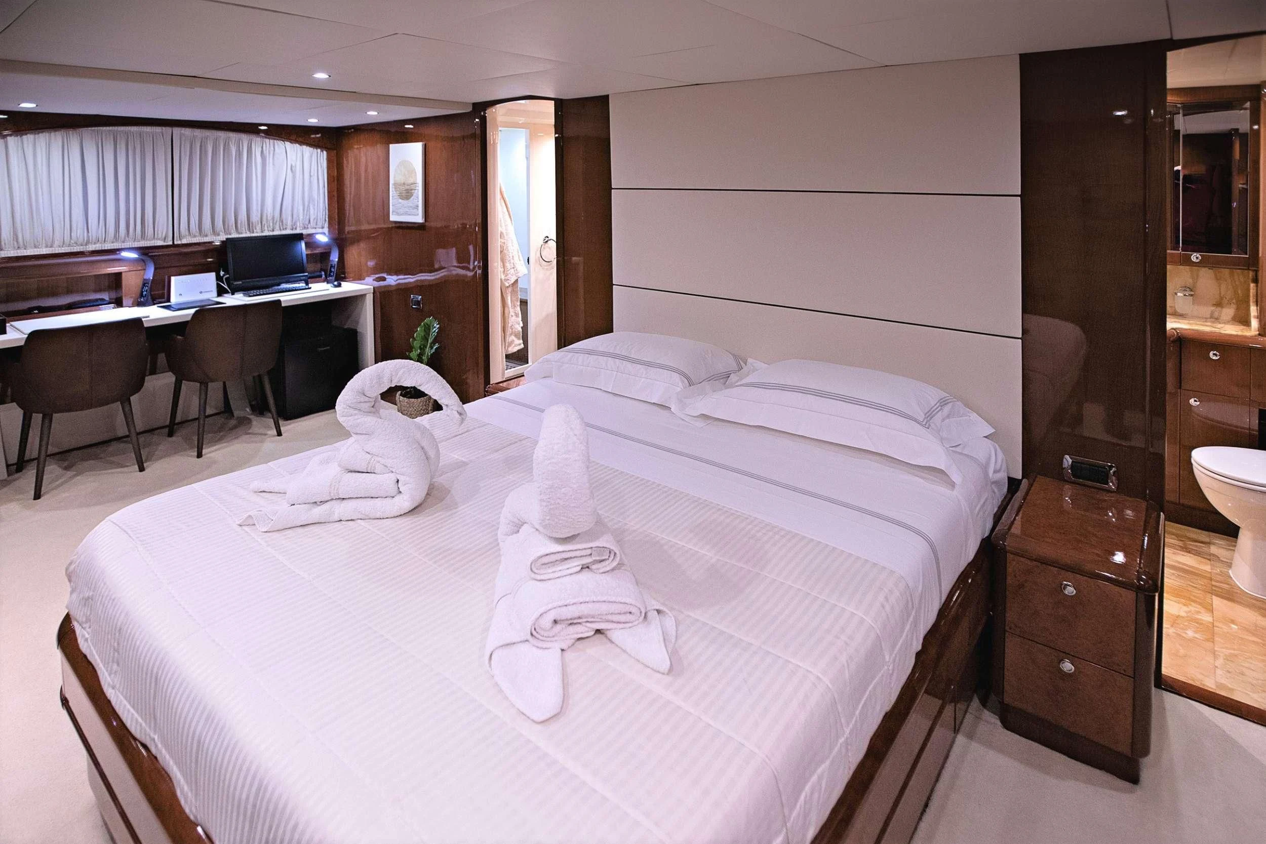 a hotel room with a bed and desk aboard THEION Yacht for Sale